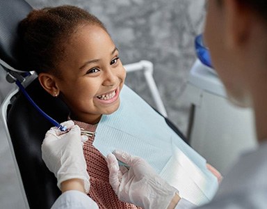 Young girl smiling at dentist during exam