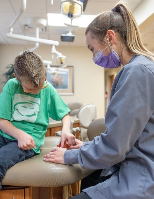 Pediatric dentist talking to child during preventive dentistry visit
