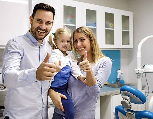 Happy parents and child in dental office