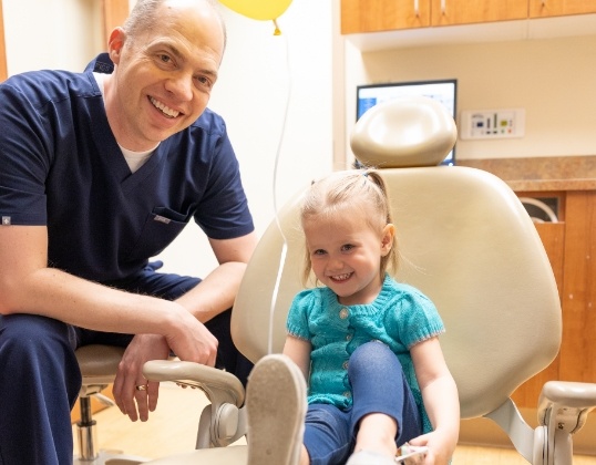 Board certified pediatric dentist and child smiling together