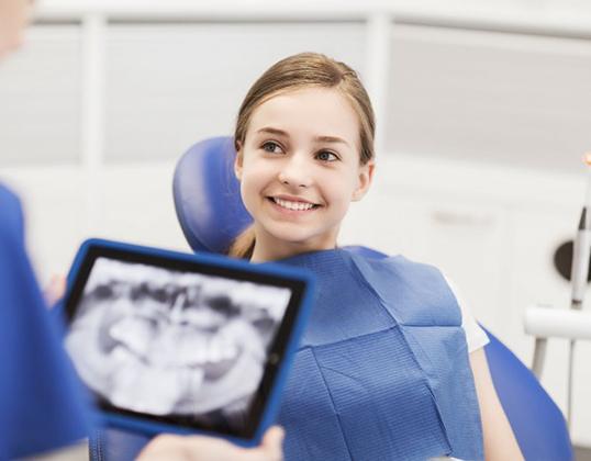 Young girl smiling and happy in the dentist&rsquo;s chair