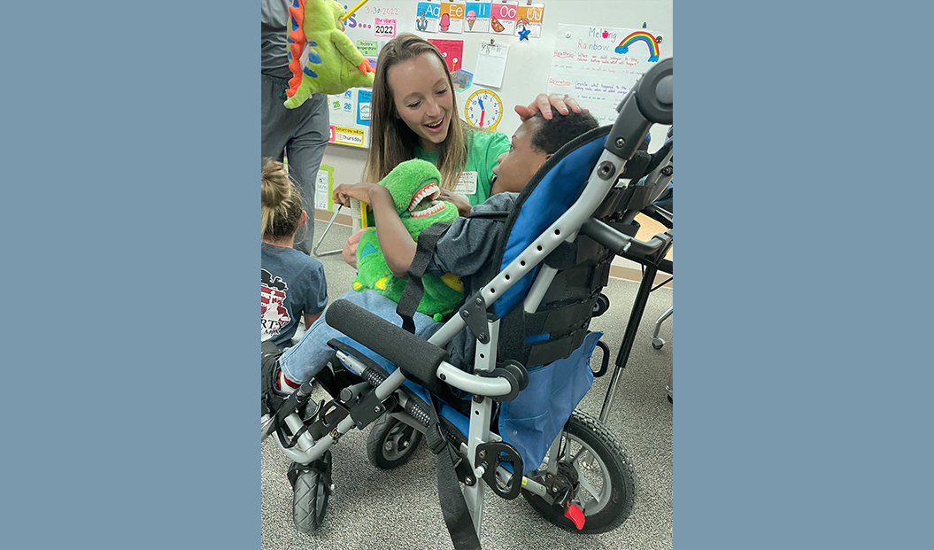 Pediatric dental team member talking to young child