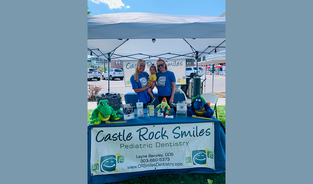 Pediatric dental team members at dental office booth during community event