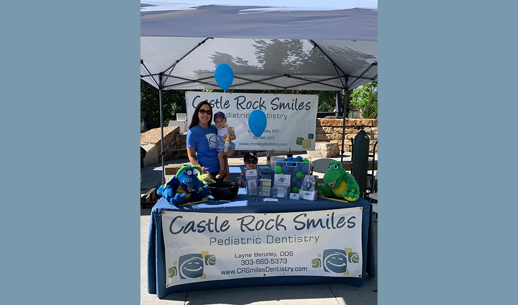 Dental team member and child at pediatric dental office booth at community event