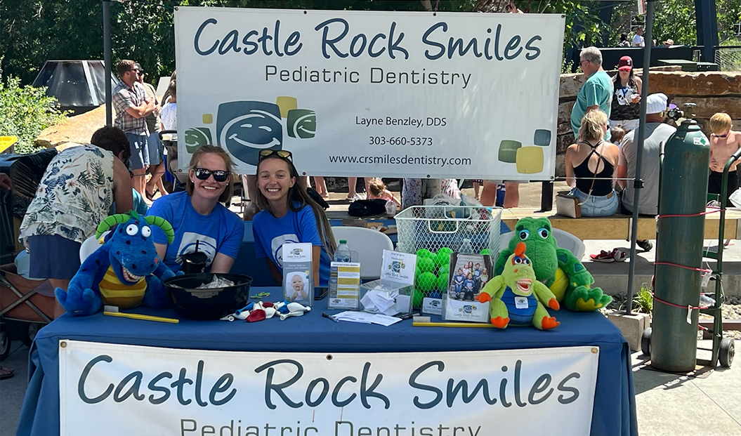 Friendly pediatric dental team members at dental office booth