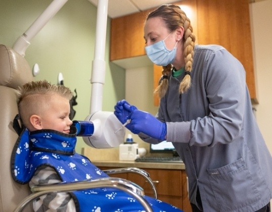 Children's dental team member treating young dentistry patient
