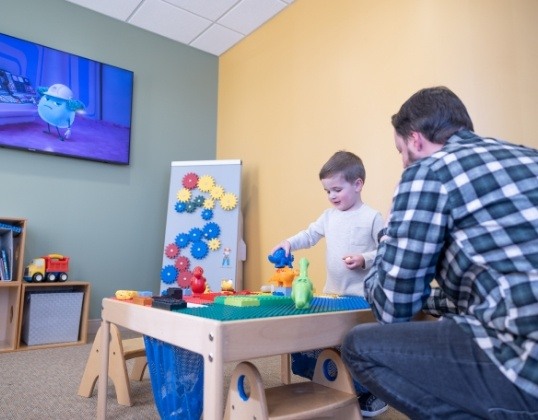 Child and parent enjoying the pediatric dental office waiting room