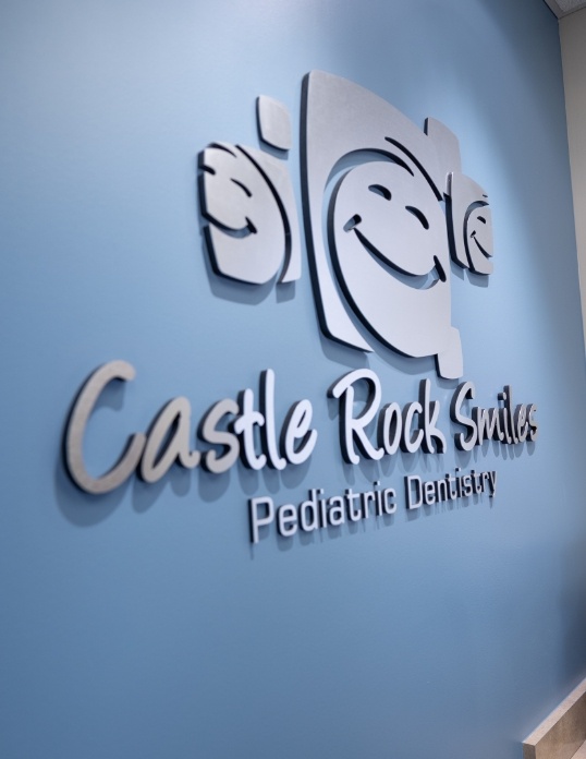 Castle Rock Smiles Pediatric Dentistry sign on children's dental office wall