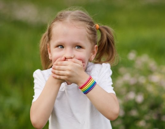 Child covering mouth before emergency dentistry