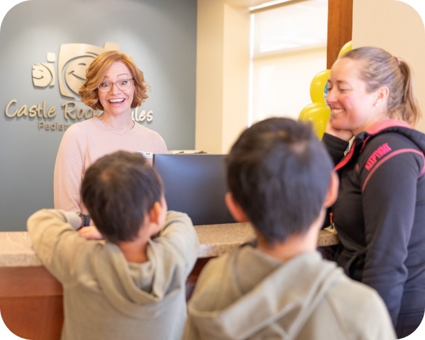 Friendly pediatric dental team member greeting dentistry patients