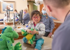 Pediatric dentist talking to smiling dental patient