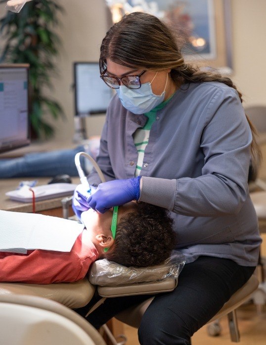 Pediatric dentist performing oral cancer screening