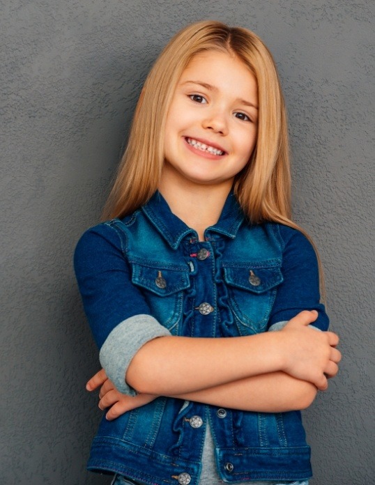 Child with pediatric dental fillings and crowns smiling