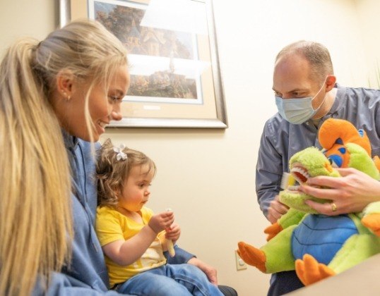 Mother and infant talking to pediatric dentist about tooth extraction