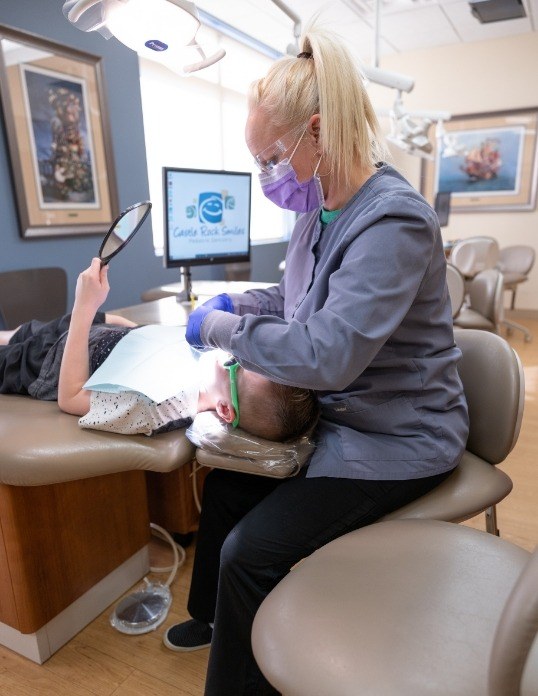 Pediatric dental team member helping child prevent dental emergencies