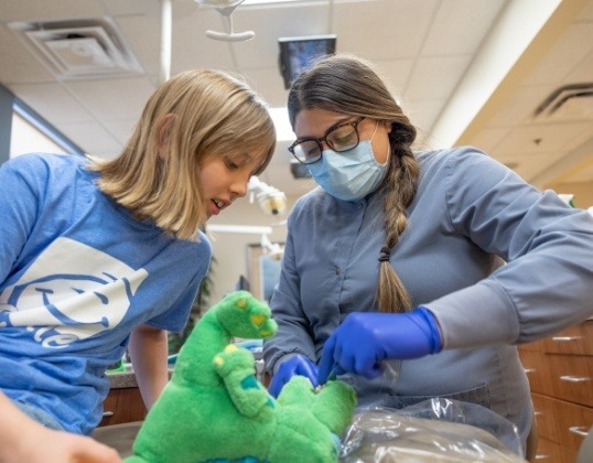 Pediatric dental team member teaching child about great oral hygiene