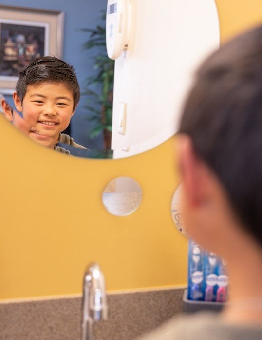 Child looking at smile after restorative dentistry