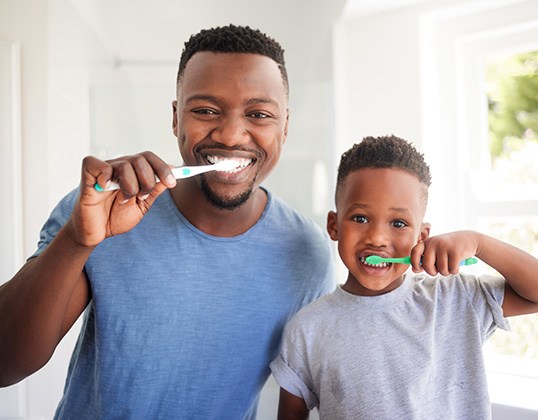 Dad and son brushing their teeth