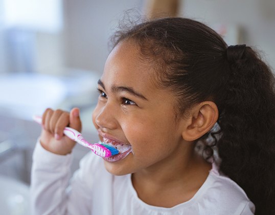 Little girl brushing her teeth at home
