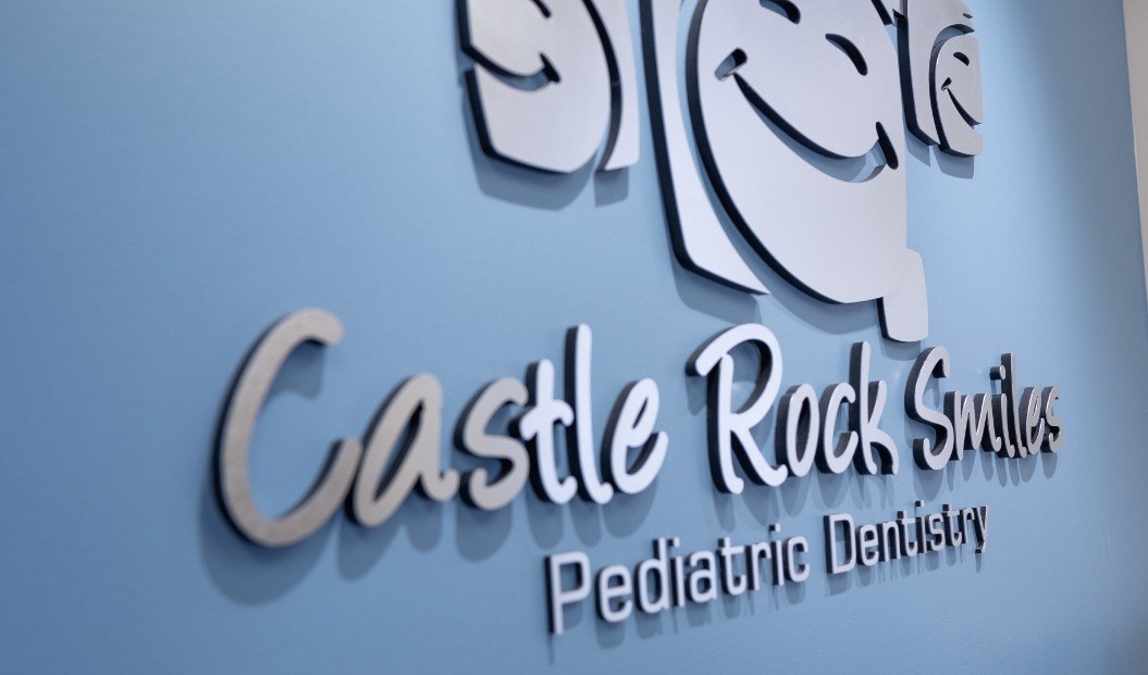 Castle Rock Smiles Pediatric Dentistry sign on children's dental office wall