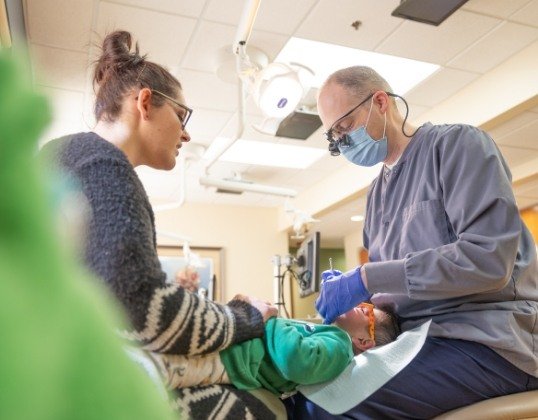 Pediatric dentist treating dental patient