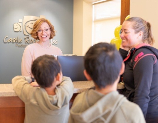 Friendly dental team member greeting young dentistry patients