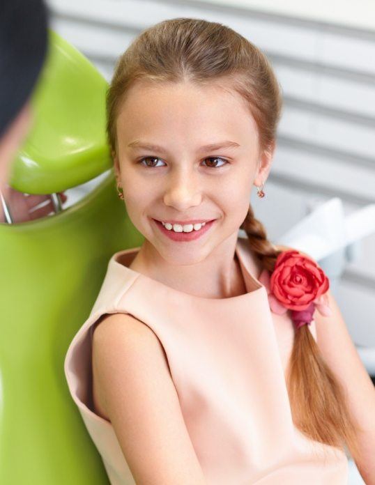 Child smiling during pediatric dental office visit