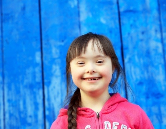 Child smiling after dentistry for special needs