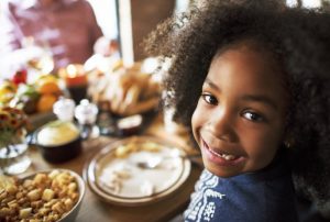 child sitting at a dinner table and eating