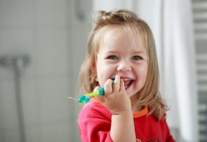 little girl brushing her teeth