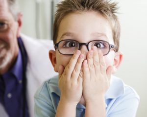 Surprised boy covering his mouth