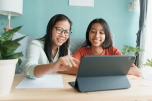 a parent and their child using a tablet together