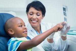 Dentist smiling at boy in pediatric dentistry office