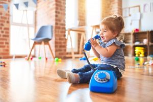 a child playing with a toy phone on a floor