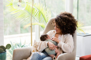 Mother sitting in chair nursing an infant