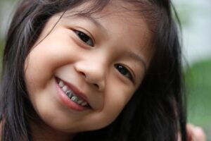 Little girl with crowns smiling.