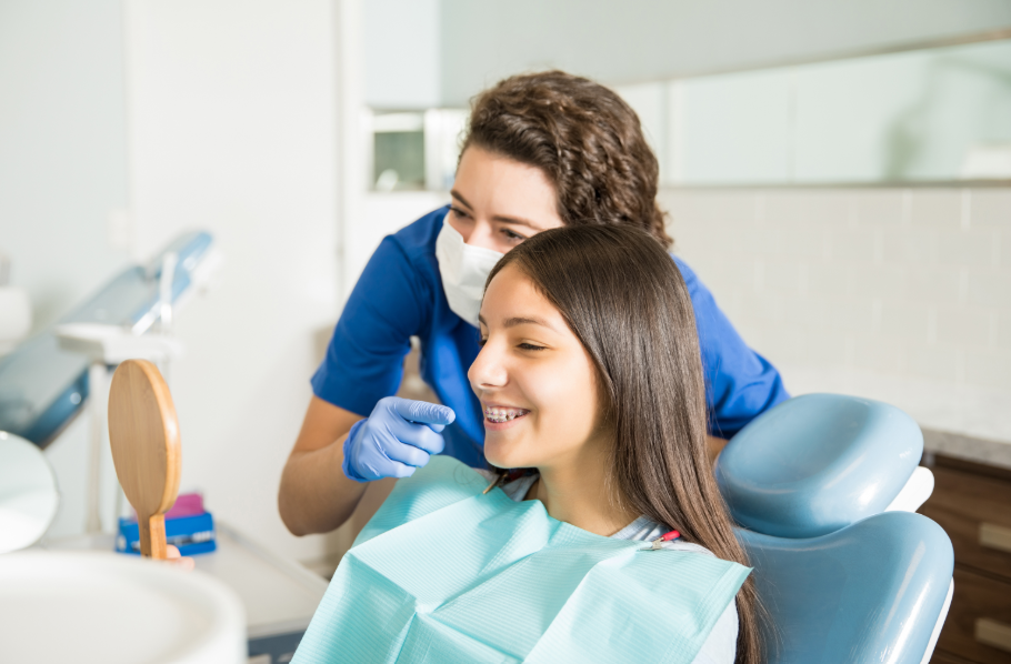 Teen in dental chair with dentist smiling